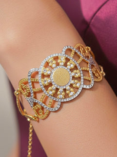 Close-up of a woman wearing an ornate traditional (Gold & Silver Polish) Bracelet. Close-up of an anti-tarnish artificial bracelet styled for wedding guests. Festive outfit paired with a premium imitation bracelet in India.