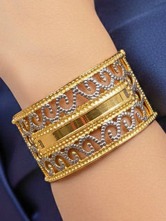 Close-up of a woman wearing an ornate traditional (Gold & Silver Polish) Bracelet. Close-up of an anti-tarnish artificial bracelet styled for wedding guests. Festive outfit paired with a premium imitation bracelet in India.