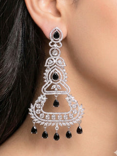Close-up of a woman wearing an ornate Western Black (Silver Polish) Long Diamond Earrings with American Diamond and Colored Stones. Close-up of American diamond earrings styled for a reception party. Elegant party wear styled with high-quality imitation American Diamond earrings.