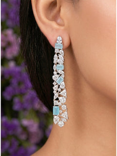 Close-up of a woman wearing an ornate Western Blue (Silver Polish) Diamond Earrings with American Diamond and Colored Stones. Close-up of American diamond earrings styled for a reception party. Cocktail party outfit paired with sparkling artificial American Diamond earrings.