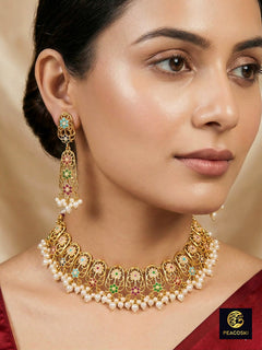Close-up of a woman wearing an ornate traditional Navratan jadau gold jewellery set and jadau earrings with navratan color stone and Pearls. Woman pairing a traditional Jadau necklace with a silk saree. Woman wearing a royal Jadau necklace for festive events in India.