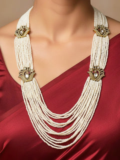 Close-up of a woman wearing an ornate traditional White Rajwadi gold Long Necklace with Pearls, American Diamond, Kundan. Festive Diwali outfit enhanced with a Rajwadi artificial necklace. Festive look completed with a luxury Rajwadi imitation necklace.