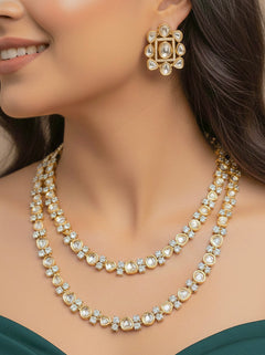 Close-up of a woman wearing an ornate Indo-western Layered Kundan (gold Polish) jewellery set and earrings with American Diamond and Kundan. Indo-western outfit styled with a lightweight Kundan necklace. Reception-ready look featuring elegant Kundan imitation jewelry.