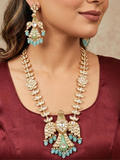 Close-up of a woman wearing an ornate traditional (Gold Polish) Sea Green Long jewellery set and earrings with Polki and Tumble Beads. Festive celebration look completed with premium imitation Polki jewelry. Woman wearing trending Polki artificial jewelry for the wedding season in India.