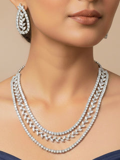 Close-up of a women wearing an ornate Indo-Western American Diamond Silver Layered Collar jewellery set and earrings with American Diamond. Close-up of a cocktail party look featuring a premium American diamond necklace. Party wear outfit completed with a lightweight American diamond necklace.