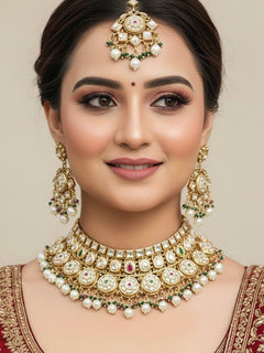 Close-up of a woman wearing an ornate traditional Rajwadi and Heritage gold Choker jewellery set and earrings and maangtikka with Pearls, Hydro Crystal and Moissanite Kundan. Bride wearing a premium Rajwadi necklace with a Lehenga for her reception. Royal bridal look completed with a statement heritage necklace set.