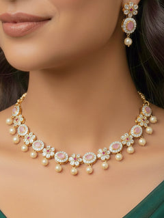 Close-up of a woman wearing an ornate traditional Mint Pink (gold Polish) Collar jewellery set and earrings with American diamonds, Pearls and Colored Stones. Festive Diwali outfit styled with an American diamond artificial necklace. Elegant wedding jewelry look featuring a premium artificial American diamond necklace.