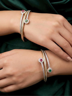 Close-up of a woman wearing an ornate Indo-Western (Silver & Gold Polish) Diamond Bangles with American Diamond and Colored stones. Elegant party wear styled with high-quality imitation American Diamond Bangles. Close-up of American diamond Bangles styled for a reception party.