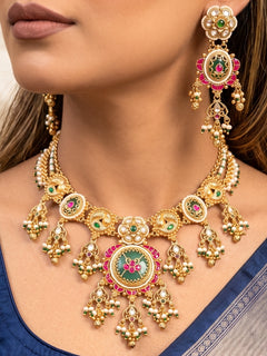 Close-up of a woman wearing an ornate traditional Mint Green Heritage gold Collar jewellery set and earrings with Pearls and Colored Stone. Saree styling inspiration with a traditional heritage necklace. Close-up of intricate antique finishing in heritage imitation jewelry.