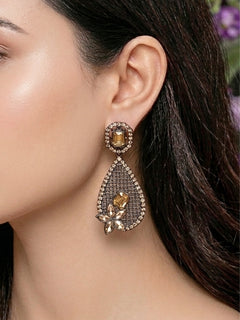 Close-up of a woman wearing an ornate Indo-Western (Black Polish) Champaign Earrings Set with American Diamond. Festive Navratri look styled with premium artificial earrings. Indo-western outfit styled with a artificial American Diamond ring.