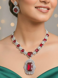 Close-up of a woman wearing an ornate Western (Silver Polish) Red Collar Jewellery Set and Earrings with American Diamond and Red Colored Stones. Party wear outfit completed with a lightweight Colored Stone necklace. Close-up of a cocktail party look featuring a premium Colored Stone necklace.