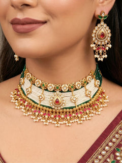 Close-up of a woman wearing an ornate traditional (Gold Polish) Choker White jewellery set and earrings with Pearl, Polki, Colored Stones, and crystal Beads. Woman wearing trending Polki artificial jewelry for the wedding season in India. Festive celebration look completed with premium imitation Polki jewelry.