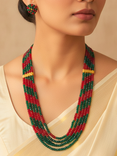 Close-up of a woman wearing an ornate traditional Red and Green Layered Jewellery Set and Earrings with Red and Green Beads. Mehendi function outfit styled with a lightweight Beads necklace.