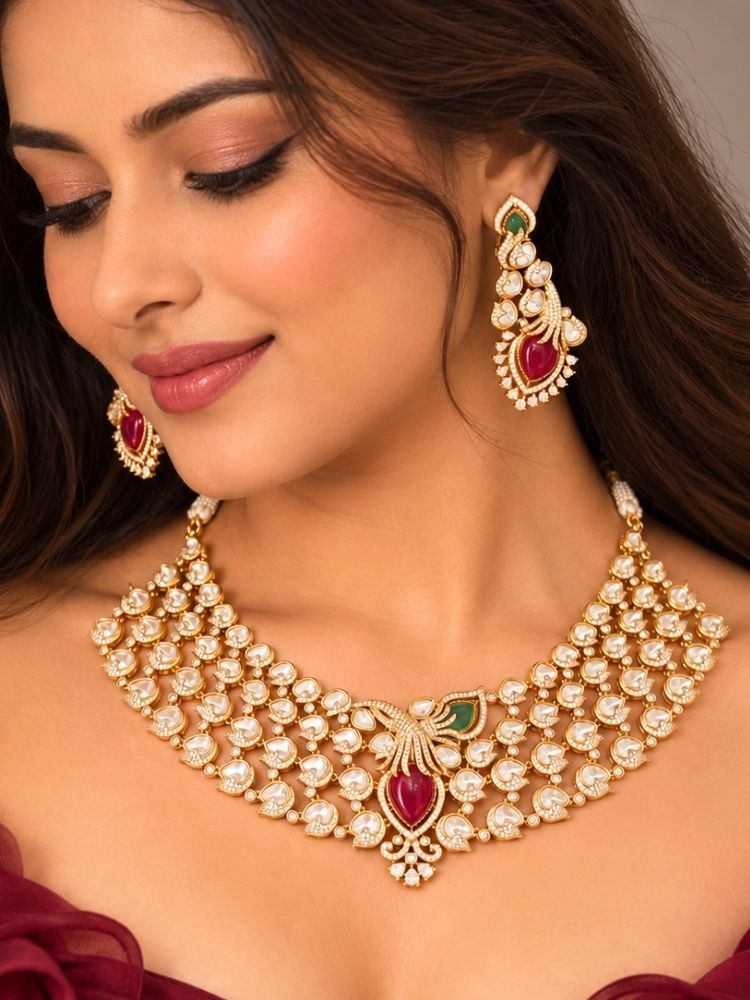 Primrose Necklace Set – woman wearing a heavy gold kundan and pearl collar necklace with ruby red centre stone and matching earrings, styled with a maroon outfit, artificial jewellery for weddings and reception