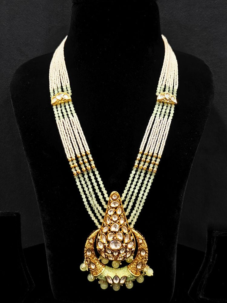 Close-up of an ornate traditional (Gold Polish) Mint Green Long jewellery set and earrings with Polki, Crystal Beads, Meenakari and Pearls. Festive Diwali look enhanced with a premium Polki artificial necklace. Saree styling inspiration with a Long Polki imitation jewelry piece.
