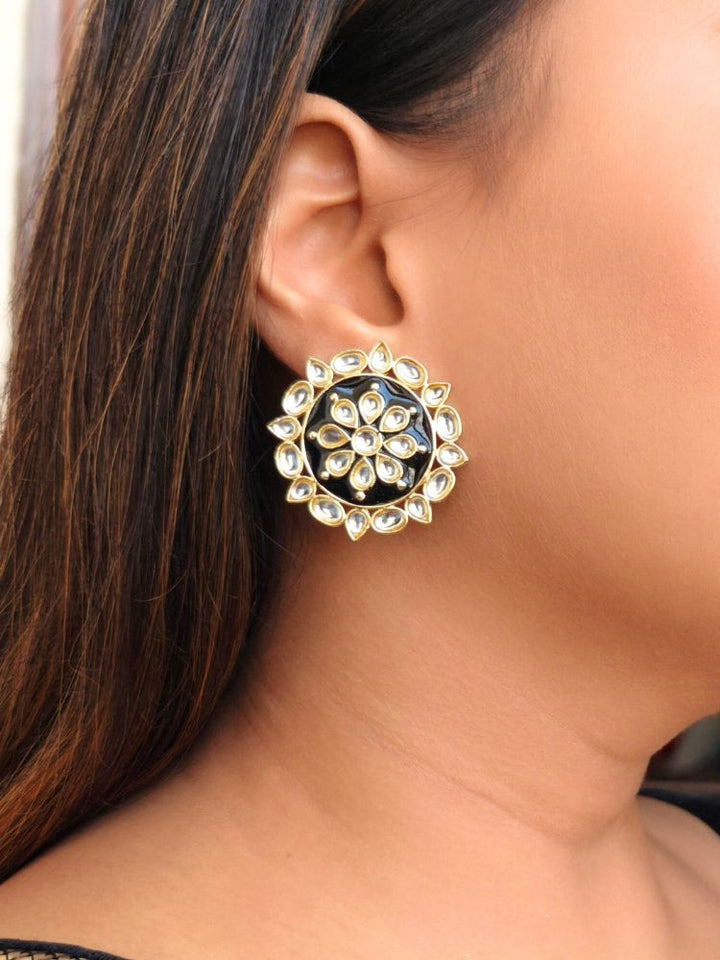 The Audrey black stud Earrings are round, gold-toned Kundan earrings, shown on a side face of a woman.