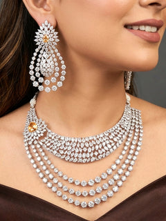 Close-up of a women wearing an ornate Western (Silver Polish) Layered jewellery set and earrings with American Diamond and Champaign Colored Stones. Elegant wedding jewelry look featuring a premium artificial American diamond necklace. A graceful woman wearing a trending American diamond necklace for a 2026 wedding celebration.