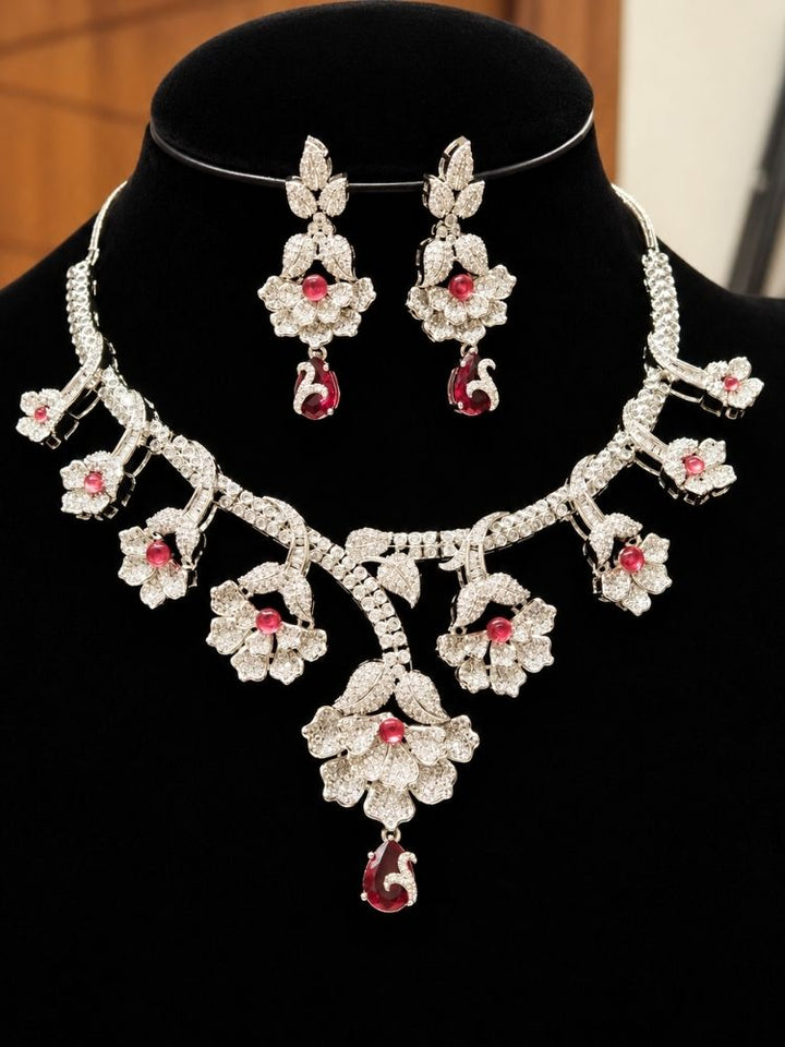 Oleander American Diamond Red Silver Tone Necklace Set on display – a silver-tone American diamond floral necklace with ruby red drops, with matching earrings, premium artificial jewellery online