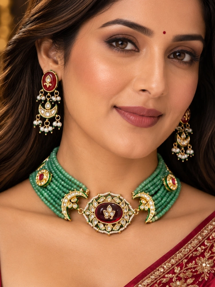 Woman in a red saree wearing a mint green bead choker with maroon Kundan centrepiece