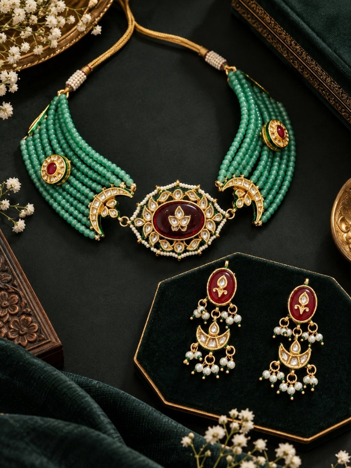 Flat lay of a green bead choker necklace set with maroon Kundan centre and adjustable dori