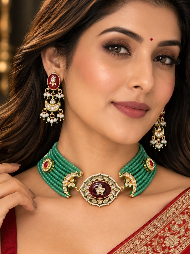 Mint green bead choker with maroon Kundan centrepiece worn with a red Banarasi saree
