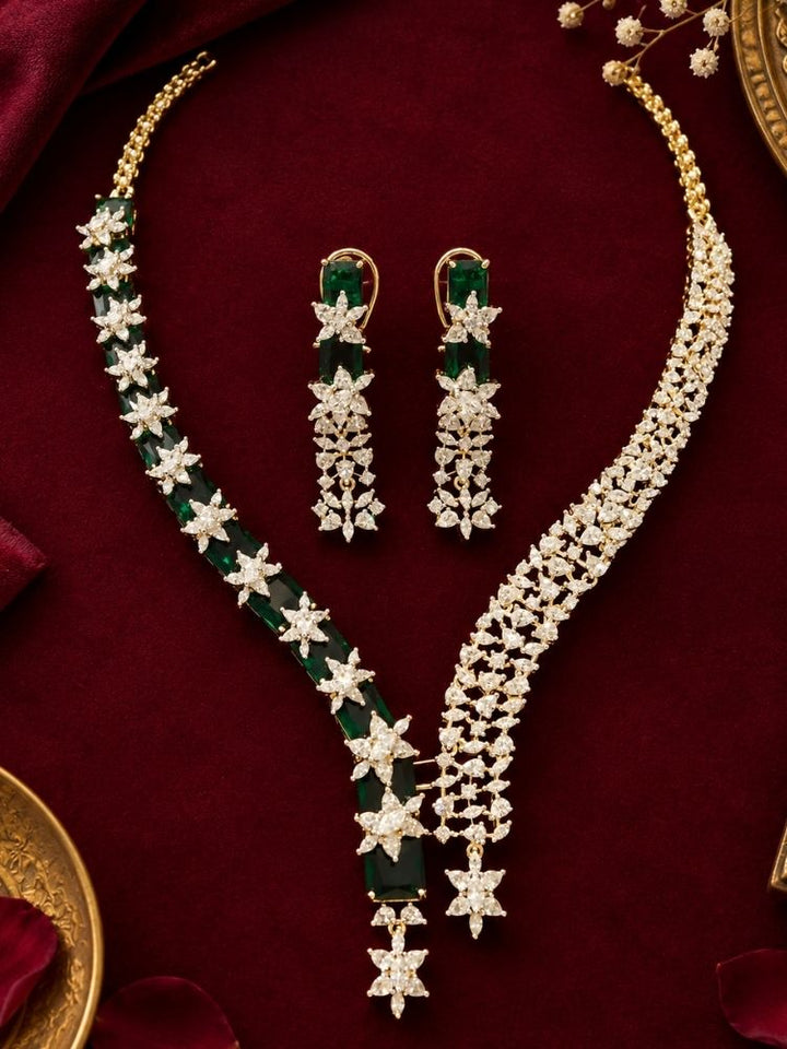Electra Green Necklace Set on display – a silver-tone American diamond necklace with emerald green stones and asymmetric drops, with matching earrings, premium artificial jewellery online