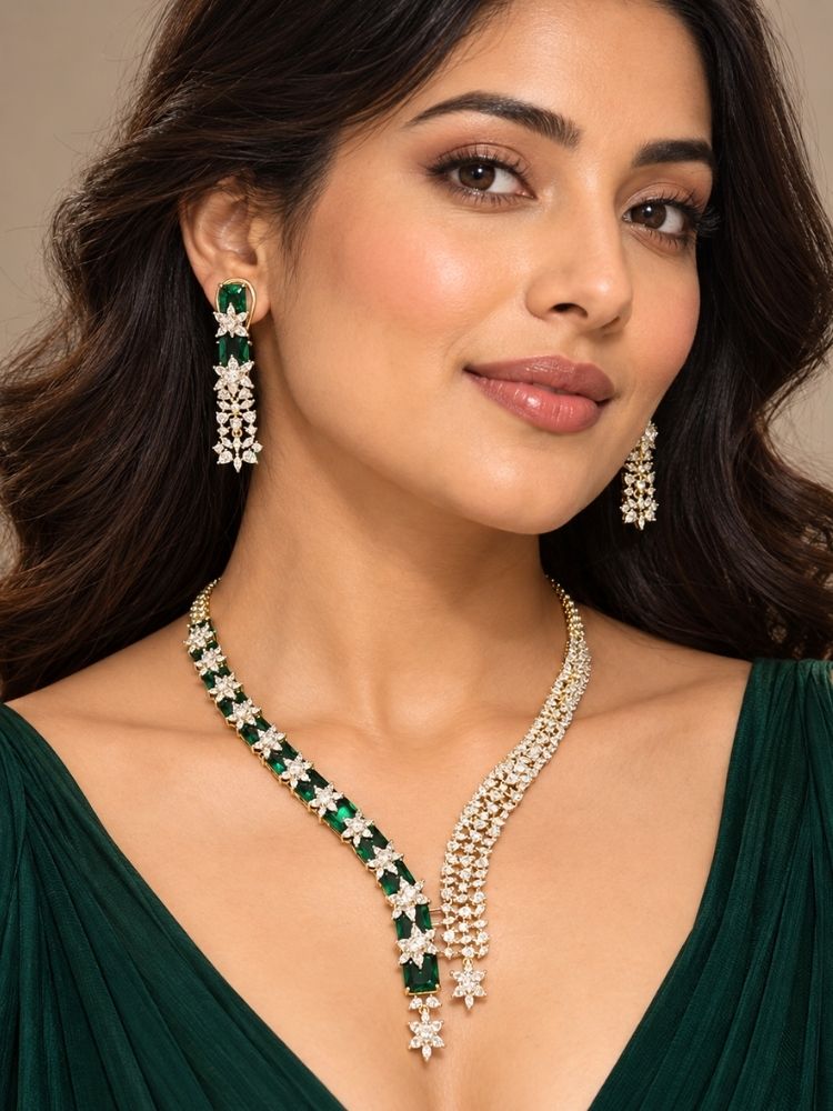 Woman wearing the Electra Green Necklace Set – a silver-tone American diamond necklace with emerald green stones and asymmetric drops, jewellery for reception, sangeet and parties