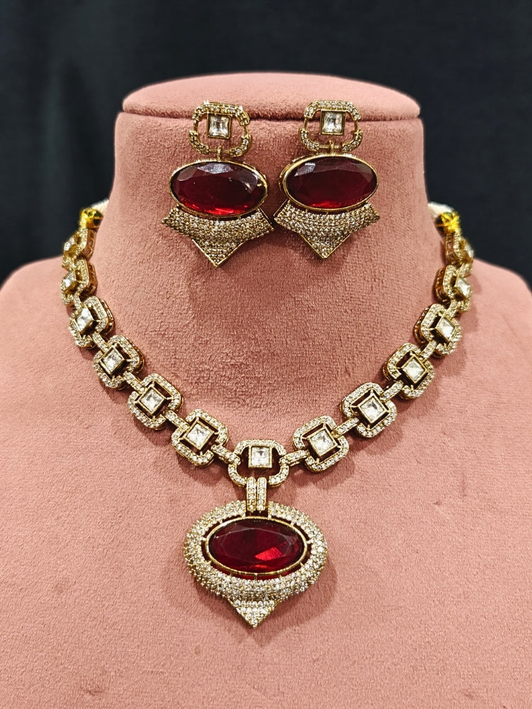 An exquisite artificial diamond and polki with red colored stone necklace and matching earrings, designed for the perfect engagement look. This stunning artificial diamond jewelry set offers luxury and sophistication while being an affordable alternative to natural diamonds.