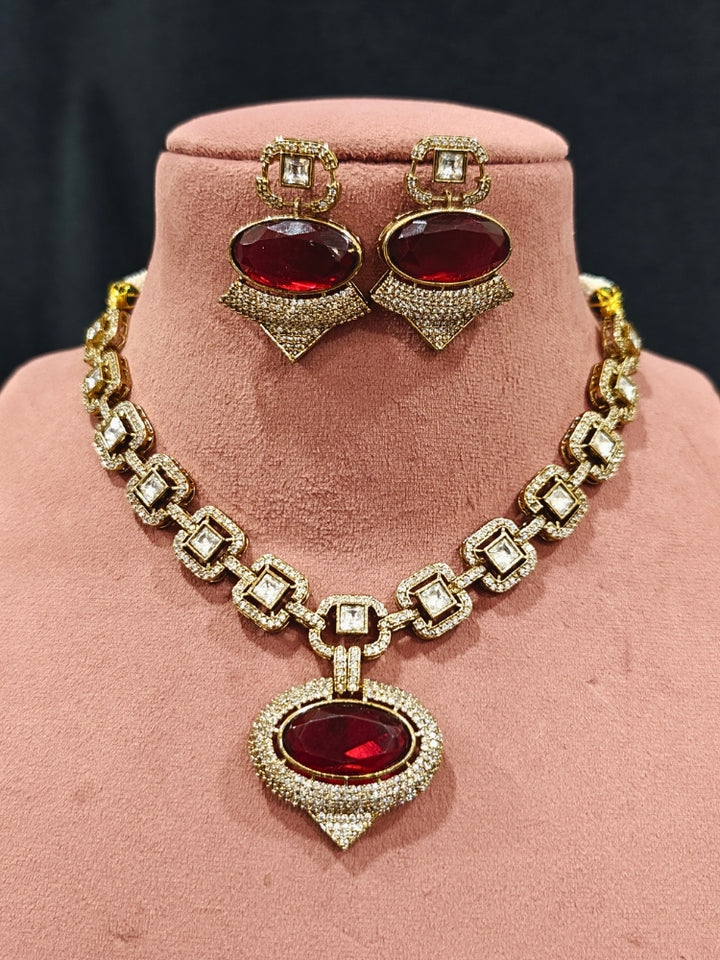 An exquisite artificial diamond and polki with red colored stone necklace and matching earrings, designed for the perfect engagement look. This stunning artificial diamond jewelry set offers luxury and sophistication while being an affordable alternative to natural diamonds.