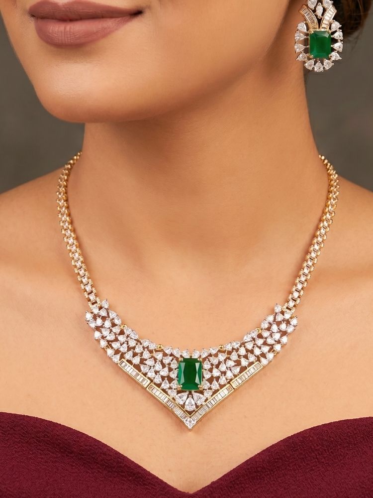 Close-up of a woman wearing an ornate Western (Silver Polish) Green Collar jewellery set and earrings with Green Colored Stone and American Diamond. Woman styling a statement American diamond necklace with an off-shoulder gown for a reception. Party wear outfit completed with a lightweight American diamond necklace.