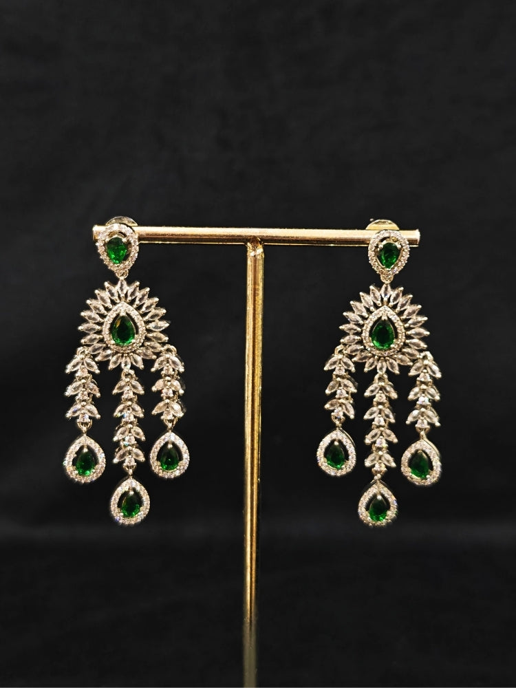Close-up of an ornate Western (Silver Polish) Diamond Green Choker jewellery set and earrings with American Diamond and Green Colored Stones. Woman styling a statement American diamond necklace with an off-shoulder gown for a reception. A graceful woman wearing a trending American diamond necklace for a 2026 wedding celebration.