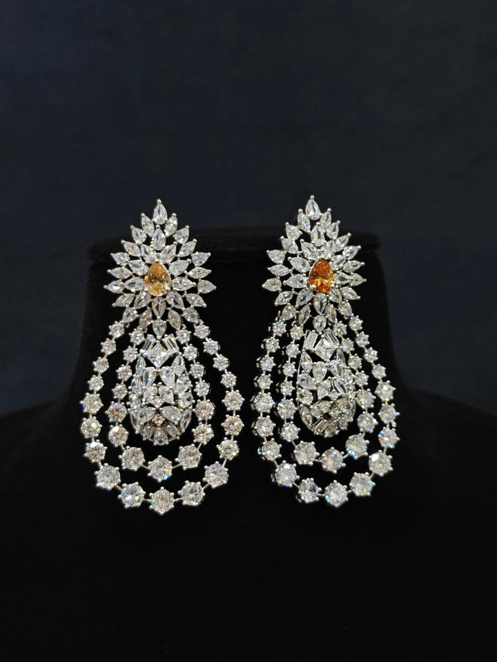 Close-up of an ornate Western (Silver Polish) Layered jewellery set and earrings with American Diamond and Champaign Colored Stones. Elegant wedding jewelry look featuring a premium artificial American diamond necklace. A graceful woman wearing a trending American diamond necklace for a 2026 wedding celebration.