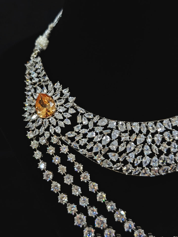 Close-up of an ornate Western (Silver Polish) Layered jewellery set and earrings with American Diamond and Champaign Colored Stones. Elegant wedding jewelry look featuring a premium artificial American diamond necklace. A graceful woman wearing a trending American diamond necklace for a 2026 wedding celebration.