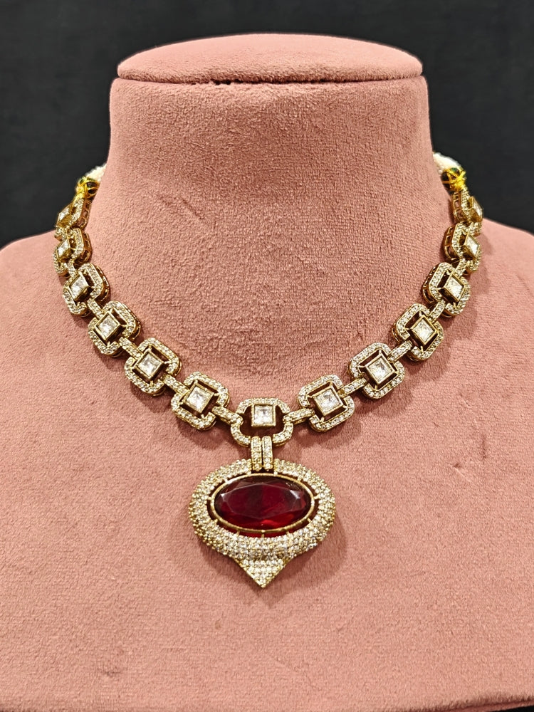 An exquisite artificial diamond and polki with red colored stone necklace and matching earrings, designed for the perfect engagement look. This stunning artificial diamond jewelry set offers luxury and sophistication while being an affordable alternative to natural diamonds.