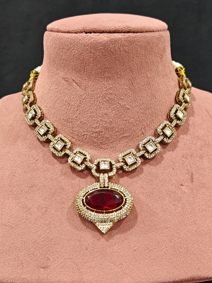 An exquisite artificial diamond and polki with red colored stone necklace and matching earrings, designed for the perfect engagement look. This stunning artificial diamond jewelry set offers luxury and sophistication while being an affordable alternative to natural diamonds.
