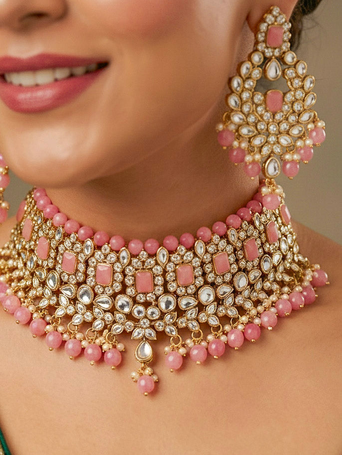 Close-up of a woman wearing an ornate traditional Pink Kundan Choker jewellery set and earrings and maangtikka with Kundan, Mint Pink Stone, Pearls and Mint Pink Crystal Beads. Bride wearing a royal Kundan artificial necklace for wedding rituals. Wedding celebration look enhanced with a statement Kundan necklace. 