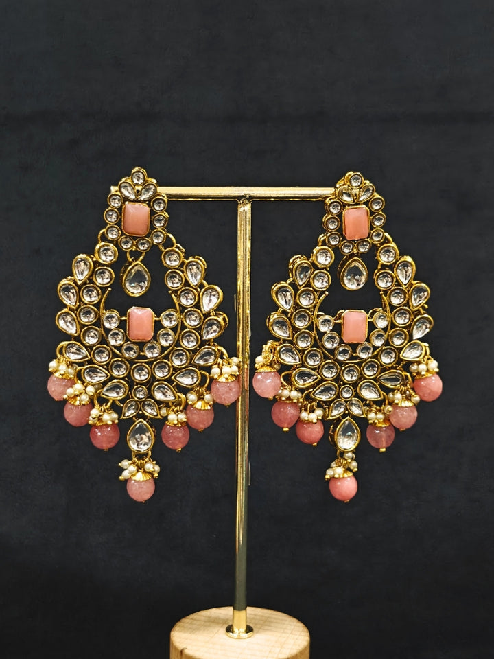 Close-up of an ornate traditional Pink Kundan Choker jewellery set and earrings and maangtikka with Kundan, Mint Pink Stone, Pearls and Mint Pink Crystal Beads. Bride wearing a royal Kundan artificial necklace for wedding rituals. Wedding celebration look enhanced with a statement Kundan necklace. 