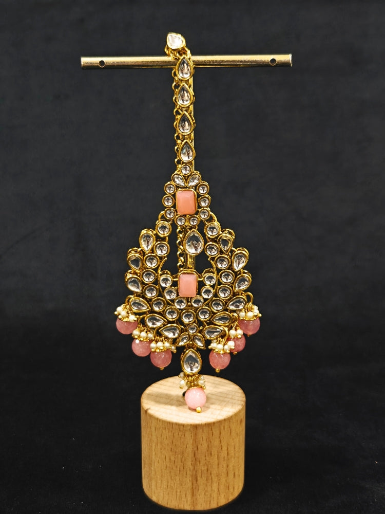 Close-up of an ornate traditional Pink Kundan Choker jewellery set and earrings and maangtikka with Kundan, Mint Pink Stone, Pearls and Mint Pink Crystal Beads. Bride wearing a royal Kundan artificial necklace for wedding rituals. Wedding celebration look enhanced with a statement Kundan necklace. 