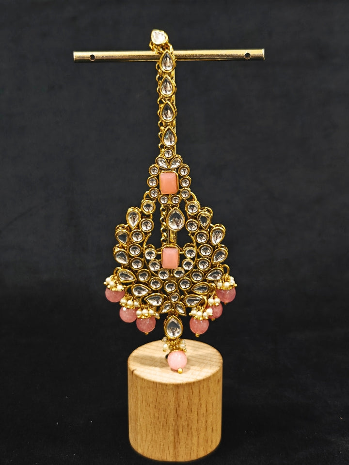 Close-up of an ornate traditional Pink Kundan Choker jewellery set and earrings and maangtikka with Kundan, Mint Pink Stone, Pearls and Mint Pink Crystal Beads. Bride wearing a royal Kundan artificial necklace for wedding rituals. Wedding celebration look enhanced with a statement Kundan necklace. 