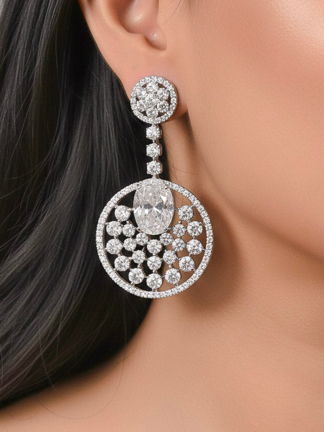 Close-up of a woman wearing an ornate Western (Silver Polish) White Diamond Earrings with American Diamond and Colored Stones. Bride wearing luxury artificial American Diamond earrings for reception night. Reception-ready look completed with statement artificial jewelry American Diamond earrings.
