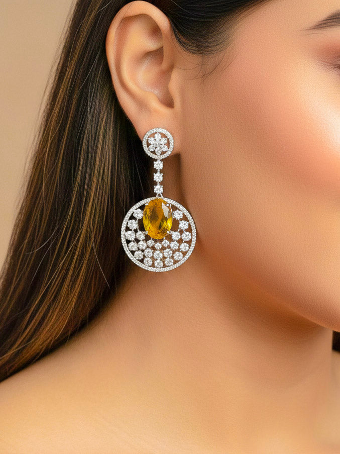 Close-up of a woman wearing an ornate Western (Silver Polish) Yellow Diamond Earrings with American Diamond and Colored Stones. Bride wearing luxury artificial American Diamond earrings for reception night. Reception-ready look completed with statement artificial jewelry American Diamond earrings.