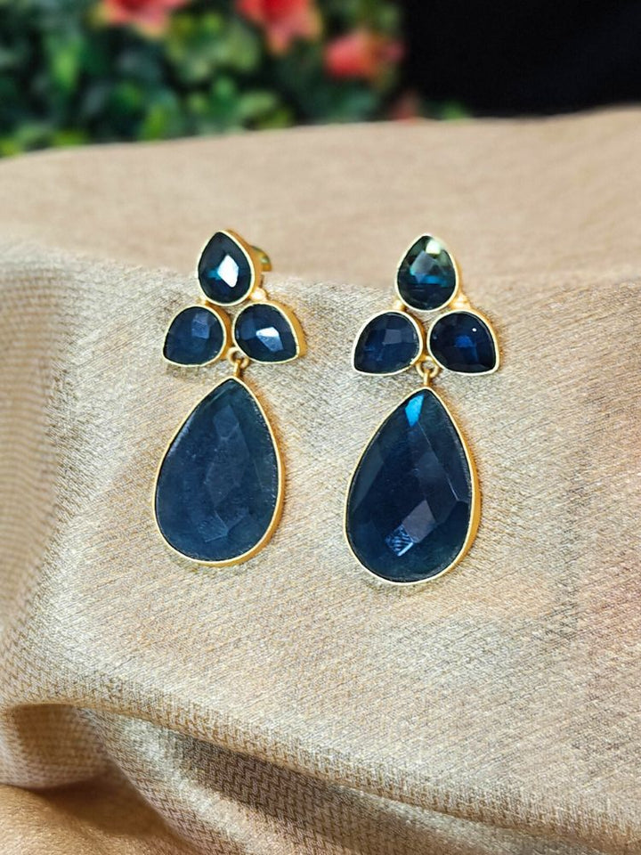 The Addison Earrings feature elegant gold borders, three faceted navy blue gemstones, and a large Monalisa Navy Blue teardrop stone—perfect for complementing your wedding ceremony dress.