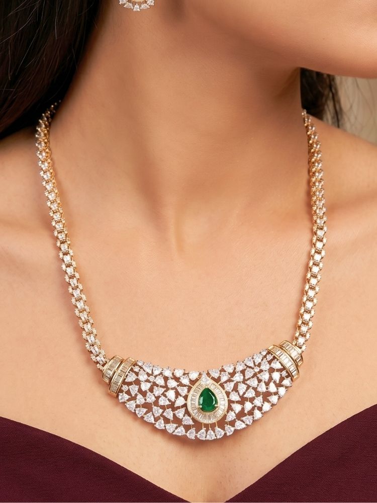 Close-up of a woman wearing an ornate Western (Silver Polish) Green Collar jewellery set and earrings with Green Colored Stone and American Diamond.Woman styling a statement American diamond necklace with an off-shoulder gown for a reception. Party wear outfit completed with a lightweight American diamond necklace.