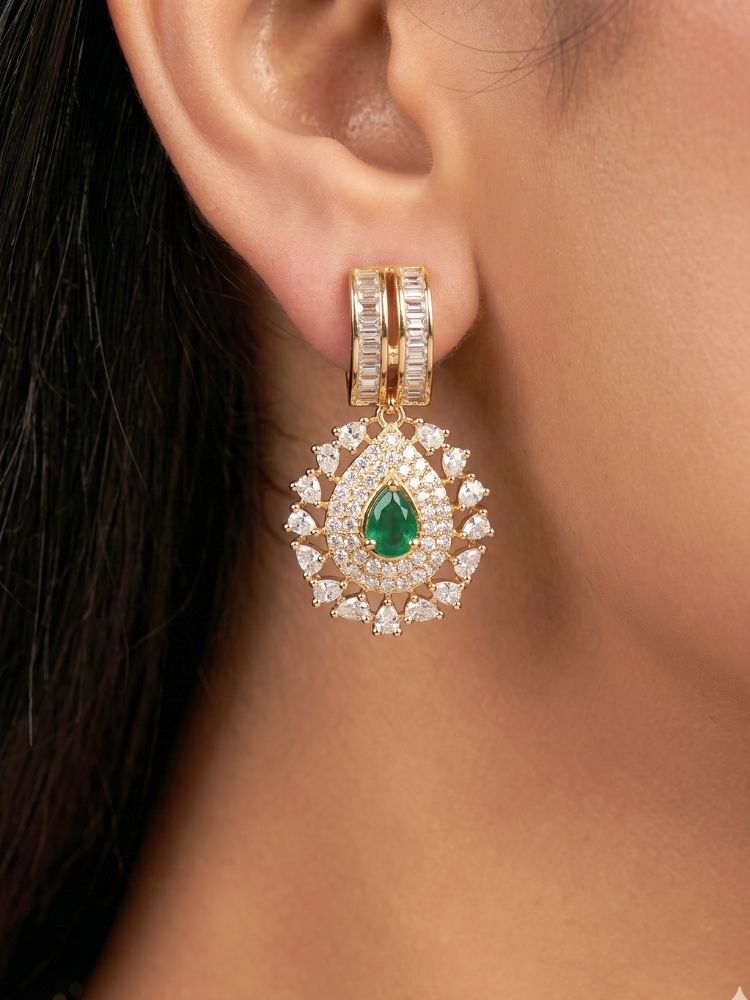 Close-up of a woman wearing an ornate Western (Silver Polish) Green Collar jewellery set and earrings with Green Colored Stone and American Diamond.Woman styling a statement American diamond necklace with an off-shoulder gown for a reception. Party wear outfit completed with a lightweight American diamond necklace.