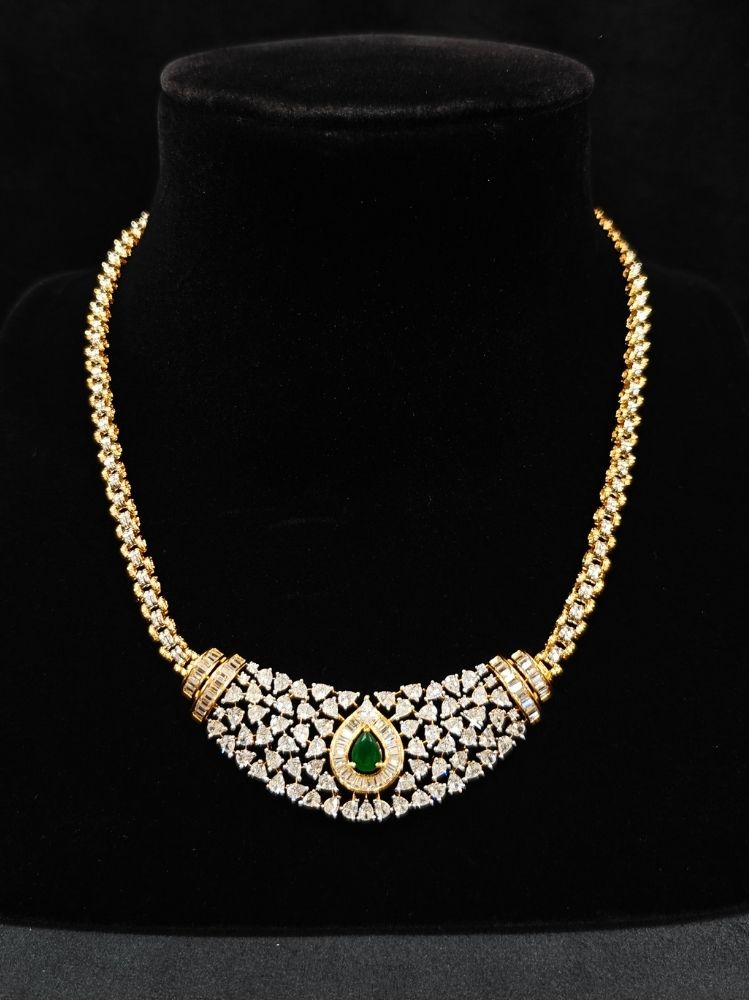 Close-up of an ornate Western (Silver Polish) Green Collar jewellery set and earrings with Green Colored Stone and American Diamond.Woman styling a statement American diamond necklace with an off-shoulder gown for a reception. Party wear outfit completed with a lightweight American diamond necklace.