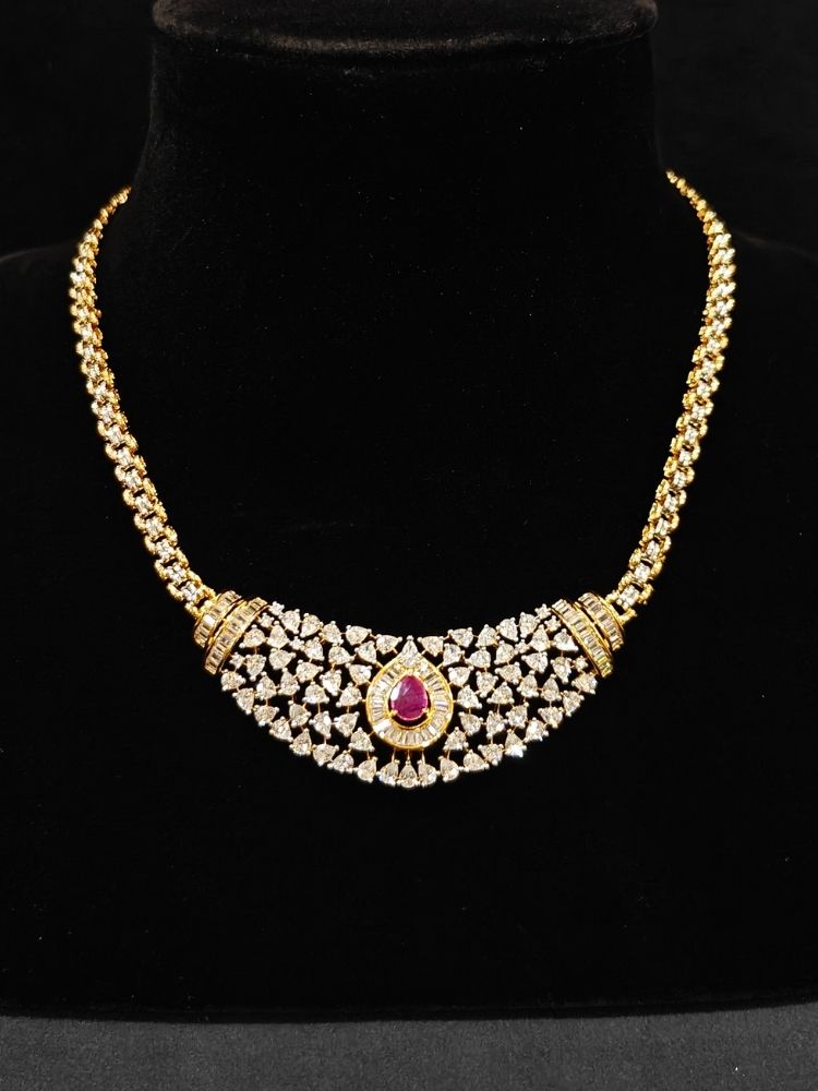 Close-up o an ornate Western (Silver Polish) Pink Collar jewellery set and earrings with Pink Colored Stone and American Diamond.Woman styling a statement American diamond necklace with an off-shoulder gown for a reception. Party wear outfit completed with a lightweight American diamond necklace.