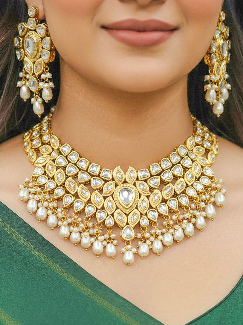 Close-up of a woman wearing an ornate traditional Gold Collar Necklace set, Eaarings and Mangtikka with Kundan, Pearls and American Diamonds. Bride wearing a traditional Kundan artificial necklace set for her wedding ceremony. Royal bridal look featuring a traditional Kundan necklace set.