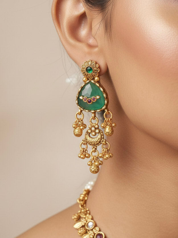 Close-up of a woman wearing an ornate traditional (Gold Polish) Mint Green Collar Haritage jewelry Set & Earrings with Color stones and kundan. Close-up of a royal heritage imitation jewelry set styled with a silk saree. Mehendi ceremony styling featuring a premium heritage artificial jewelry piece.