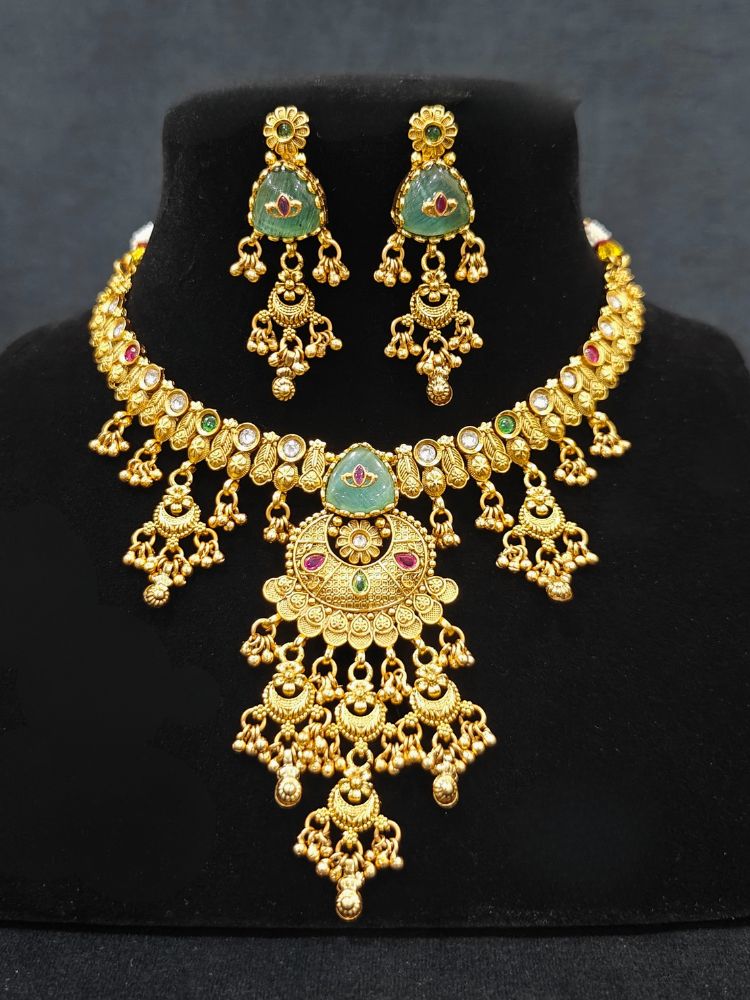 Close-up of a woman wearing an ornate traditional (Gold Polish) Mint Green Collar Haritage jewelry Set & Earrings with Color stones and kundan. Close-up of a royal heritage imitation jewelry set styled with a silk saree. Mehendi ceremony styling featuring a premium heritage artificial jewelry piece.