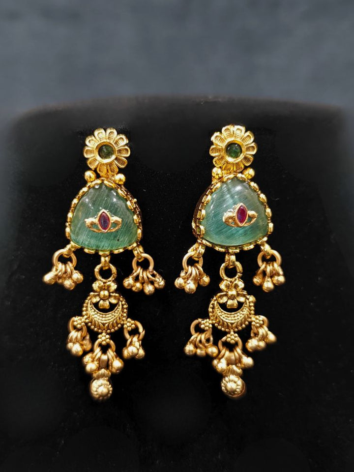 Close-up of a woman wearing an ornate traditional (Gold Polish) Mint Green Collar Haritage jewelry Set & Earrings with Color stones and kundan. Close-up of a royal heritage imitation jewelry set styled with a silk saree. Mehendi ceremony styling featuring a premium heritage artificial jewelry piece.